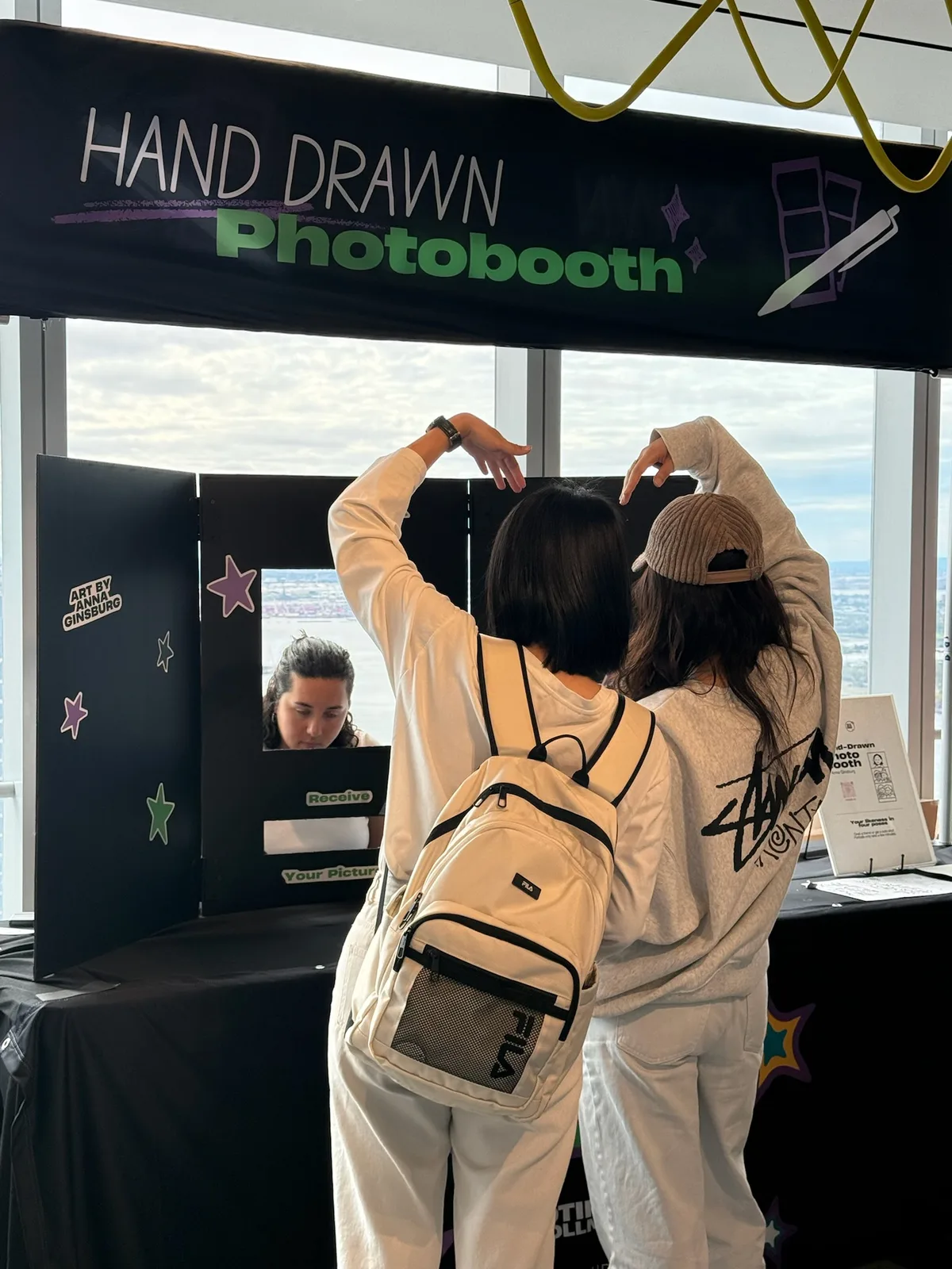 Two guests posing together at the hand-drawn photo booth