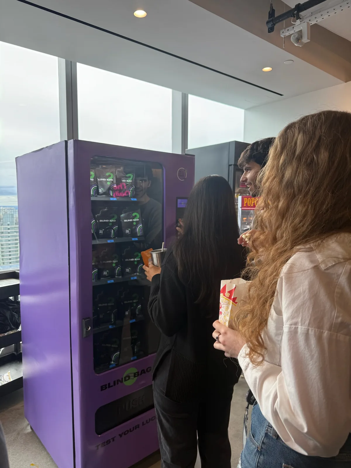 A guest choosing a surprise giveaway from the purple blind-box vending machine