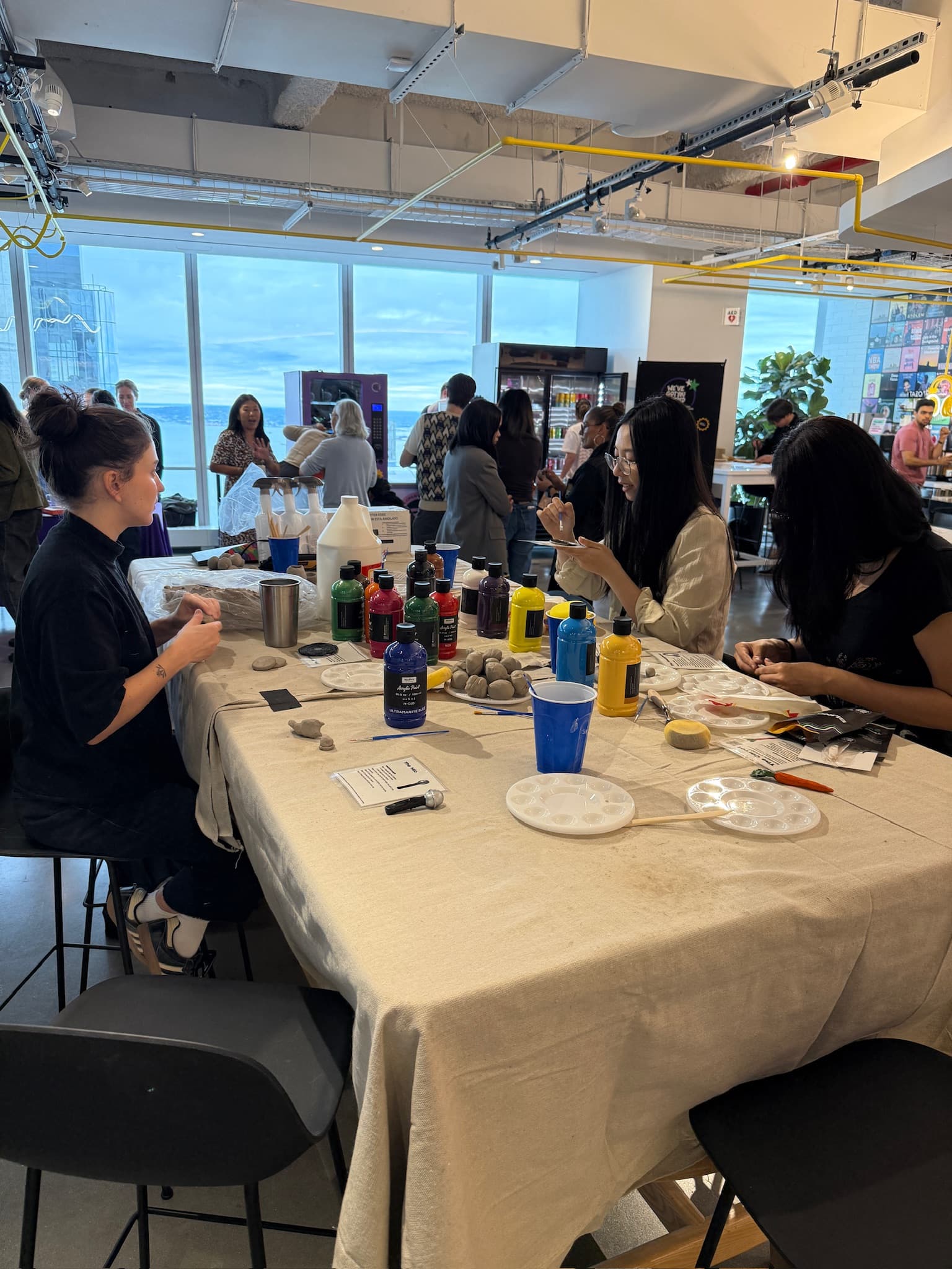 Employees sculpting clay at a corporate wellness event clay station